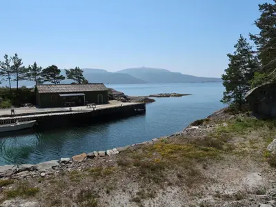 a building on a dock next to a body of water at Holiday Home Nesjevik by Interhome in Bø