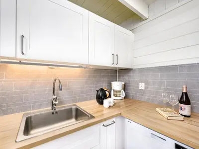 a kitchen with white cabinets and a stainless steel sink at Holiday Home Balder by Interhome in Arnefjord
