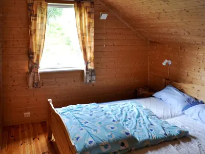 a bed in a log cabin with a window at Holiday Home Naustet by Interhome in Sylte