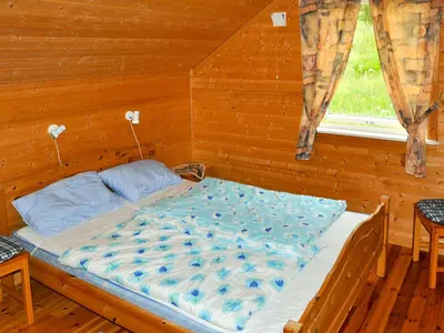 a bed in a wooden room with a window at Holiday Home Naustet by Interhome in Sylte