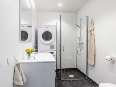 a white bathroom with a washing machine and a sink at Holiday Home Torsk by Interhome in Bømlo