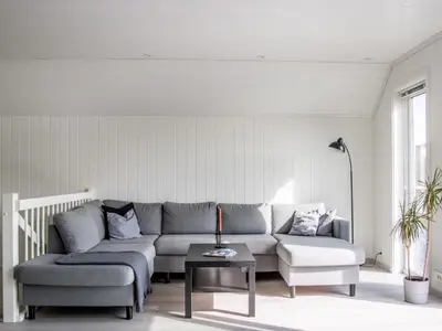 a living room with a couch and a table at Holiday Home Torsk by Interhome in Bømlo
