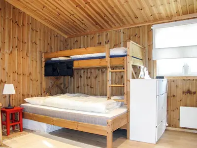 a bedroom with two bunk beds in a wooden wall at Chalet Skeisvegen by Interhome in Svingvoll