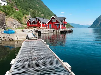 a red house on a dock in the water at Holiday Home Krokeggi by Interhome in Arnefjord