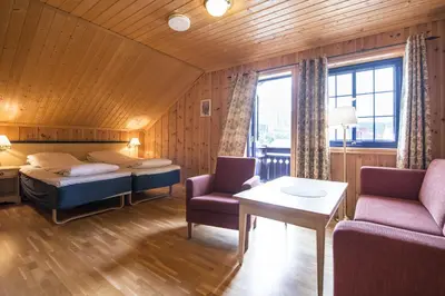 a bedroom with a bed and a couch and a table at Berkåk Gjestegård in Berkåk