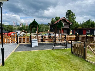 a park with a playground with a wooden fence at Berkåk Gjestegård in Berkåk