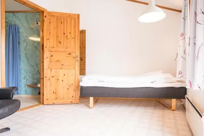 a small bedroom with a bed and a sliding door at Berkåk Gjestegård in Berkåk