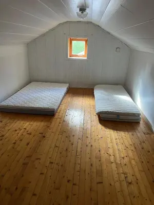 two beds in a room with a wooden floor at Hytte Elvdal in Nymoen