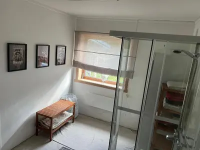 a bathroom with a shower and a bench next to a window at Hytte Elvdal in Nymoen