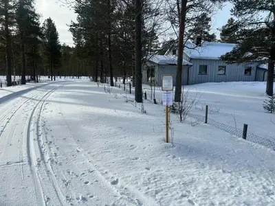 a snow covered road with a sign in the middle at Hytte Elvdal in Nymoen