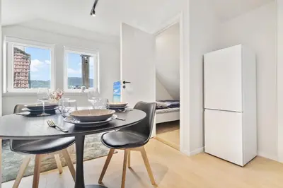 a dining room with a table and chairs and a bed at Luxury Suite in Charming Area in Bergen