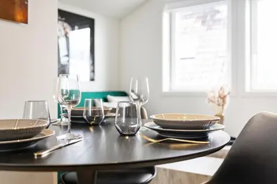 a table with wine glasses and plates on it at Luxury Suite in Charming Area in Bergen