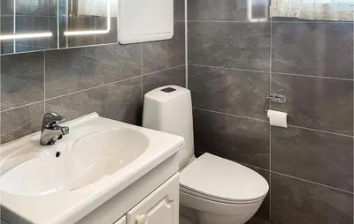 a bathroom with a white sink and a toilet at 4 Bedroom Awesome Home In Engerdal in Nymoen