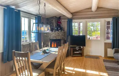 a dining room with a table and a fireplace at 4 Bedroom Awesome Home In Engerdal in Nymoen