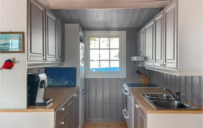a kitchen with gray cabinets and a sink and a window at 4 Bedroom Awesome Home In Engerdal in Nymoen