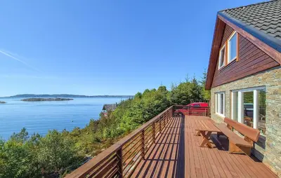 a house with a deck with a view of the water at Awesome Home In Sveio With Wifi in Sveio