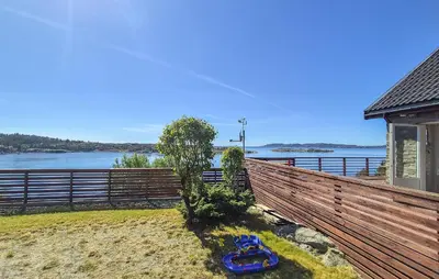 a house with a wooden fence and a tree at Awesome Home In Sveio With Wifi in Sveio