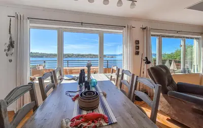 a dining room with a table and chairs and a view of the water at Awesome Home In Sveio With Wifi in Sveio