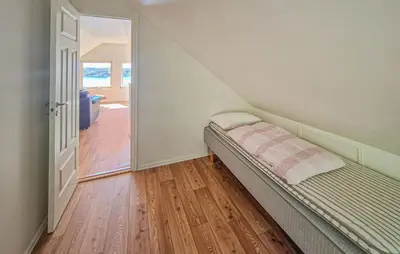 a small bed in a room with a staircase at Awesome Home In Sveio With Wifi in Sveio