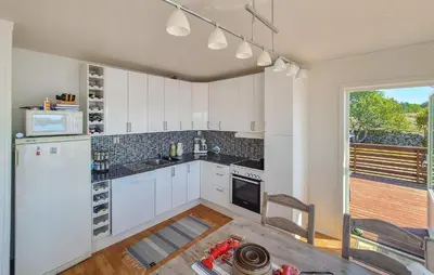 a kitchen with white cabinets and a white refrigerator at Awesome Home In Sveio With Wifi in Sveio