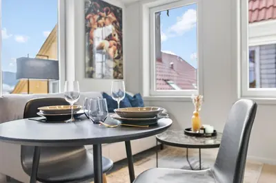 a dining room with two tables and chairs with wine glasses at Exclusive Bergen Suite in Bergen