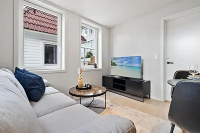 a living room with a couch and a tv at Exclusive Bergen Suite in Bergen
