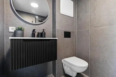a bathroom with a toilet and a mirror at Exclusive Bergen Suite in Bergen