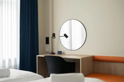 a bedroom with a mirror on a desk at BREEZE Hotel Victoria - Self-Service in Bergen
