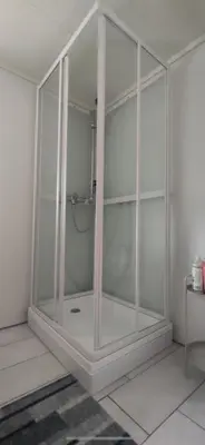 a large glass shower in a room with a table at Gulthus in Odda
