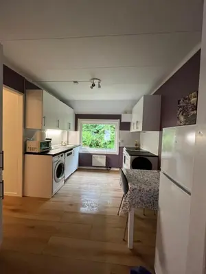 a kitchen with white appliances and a table and a window at Gulthus in Odda