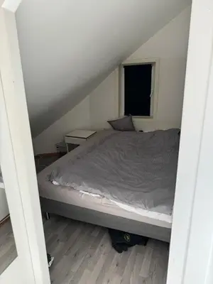 a bed in a small room with a window at Spacious and central apartment I 250m from Bryggen in Bergen