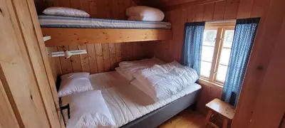 a small room with two bunk beds and a window at Buviken Nordre, Femund in Sømådalen