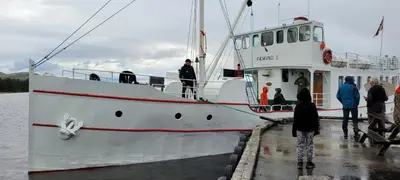 a group of people standing on a boat in the water at Buviken Nordre, Femund in Sømådalen