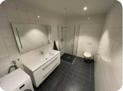 a bathroom with a sink and a shower and a toilet at Moderne Leilighet in Stord