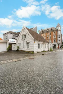 a white house sitting on the side of a street at BUDGETEL- Kong Oscarsgate 44 in Bergen