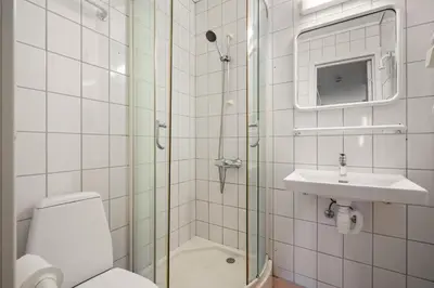 a bathroom with a shower and a toilet and a sink at BUDGETEL- Kong Oscarsgate 44 in Bergen