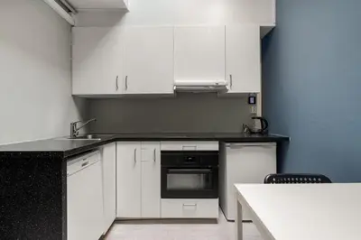 a kitchen with white cabinets and a counter top at BUDGETEL- Kong Oscarsgate 44 in Bergen