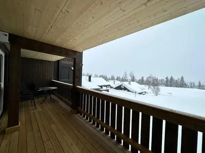 a wooden porch with a view of a snow covered yard at Family-Friendly Apartment Steps From Everything in Beitostøl