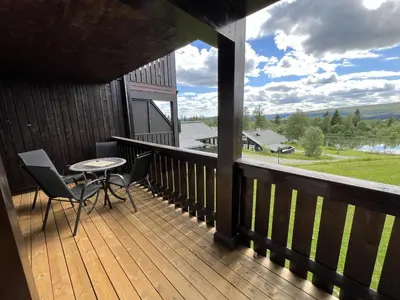 a balcony with a table and chairs and a view at Family-Friendly Apartment Steps From Everything in Beitostøl