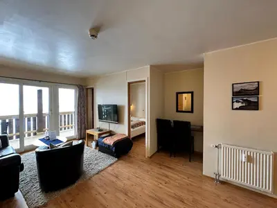 a living room with a couch and a desk and a television at Family-Friendly Apartment Steps From Everything in Beitostøl