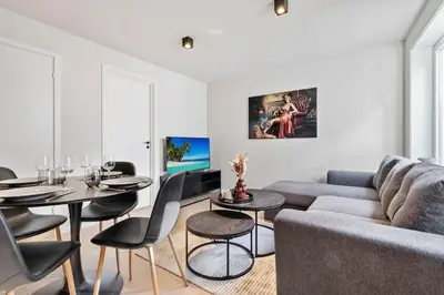 a living room with a couch and a table and chairs at Premium Bergen Suite in Bergen