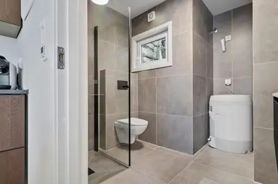 a bathroom with a toilet and a glass shower at Premium Bergen Suite in Bergen