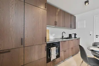 a kitchen with wooden cabinets and a stove at Premium Bergen Suite in Bergen