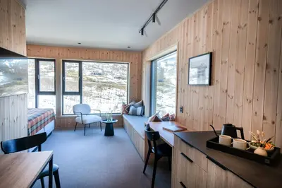 a room with wood paneled walls and a bedroom at Filefjellstuene Hotel in Tyinkrysset