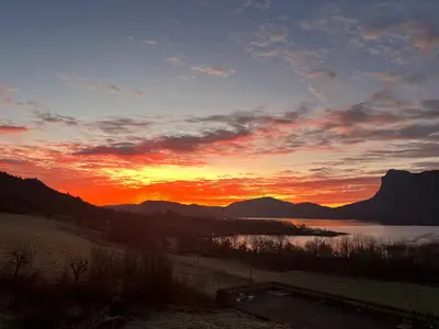 a sunset over a body of water with mountains at Øen Hytter 1 in Sørbø