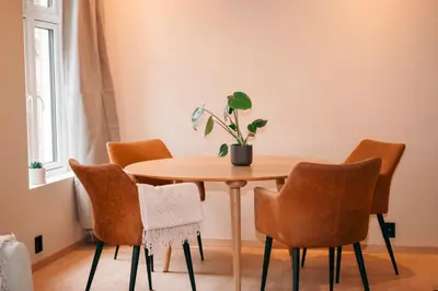 a dining room table and chairs with a potted plant on it at Bergen City Apartment in Bergen