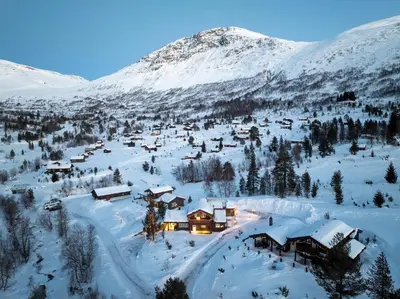 a small village in the snow with a mountain at Spacious Mountain Lodge Stryn in Stryn