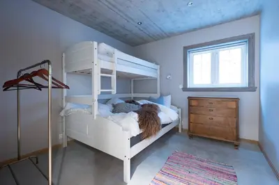 a bedroom with a white bunk bed and a dresser at Spacious Mountain Lodge Stryn in Stryn