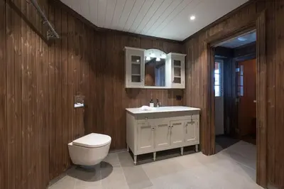 a wooden bathroom with a toilet and a sink at Spacious Mountain Lodge Stryn in Stryn