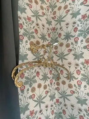 a gold door handle on a wall with flowers at Jugend 1902 in Ålesund